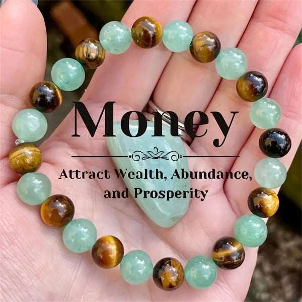 A bracelet made of light green and amber natural stone beads is shown on a person's hand.