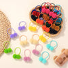 A collection of colorful double plush elastic hair bands in shades of pink, yellow, blue, and orange arranged on a wooden tra