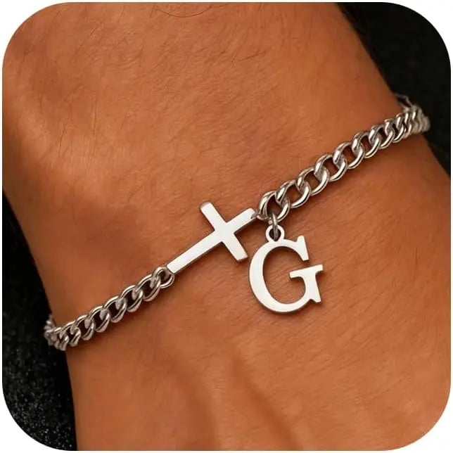 A close-up of a personalized stainless steel cross Cuban chain bracelet worn on a wrist.