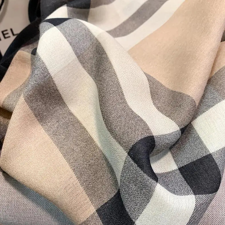 Nahaufnahme eines luxuriösen Baumwoll-Pashmina-Schals mit grau-weiß kariertem Muster.