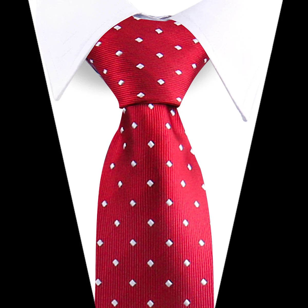 A red silk necktie with a white floral paisley pattern displayed against a white shirt collar.