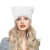 A model wearing a white crocheted cat ears beanie hat with long blonde hair.