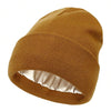 A brown knit beanie hat with a satin lining shown from the side.