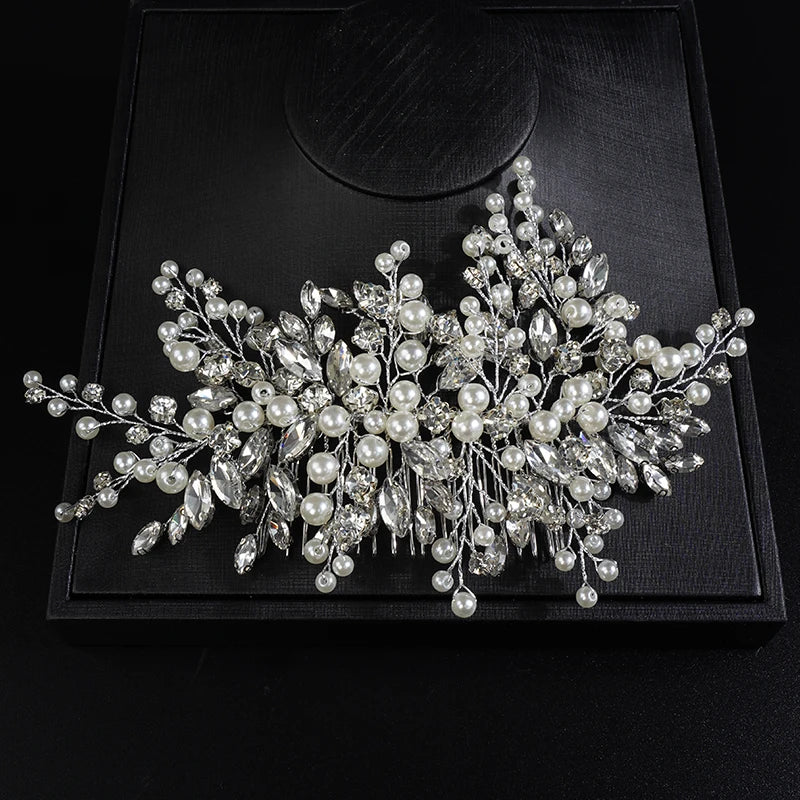A delicate bridal headpiece featuring white pearls and clear rhinestones arranged in a floral spray.