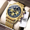 Reloj cronógrafo de lujo masculino tono dorado con esfera azul y correa negra, mostrado en una caja blanca.