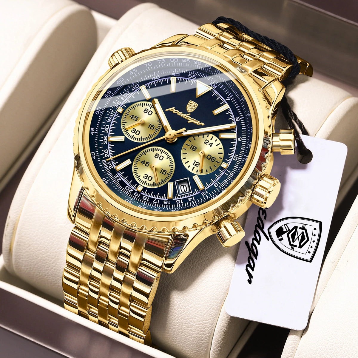 Reloj cronógrafo de lujo masculino tono dorado con esfera azul y correa negra, mostrado en una caja blanca.