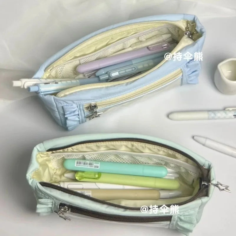 A light blue lace pencil case is open, showing various colored pencils and pens inside.