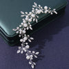 An elegant bridal hairband featuring delicate white pearls and silver leaves.