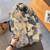 Beige und blau gemusterter Seidenschal aus Baumwolle auf einem Holztablett.