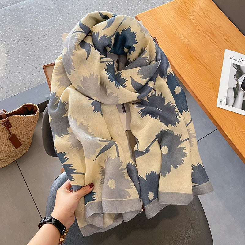 Beige und blau gemusterter Seidenschal aus Baumwolle auf einem Holztablett.