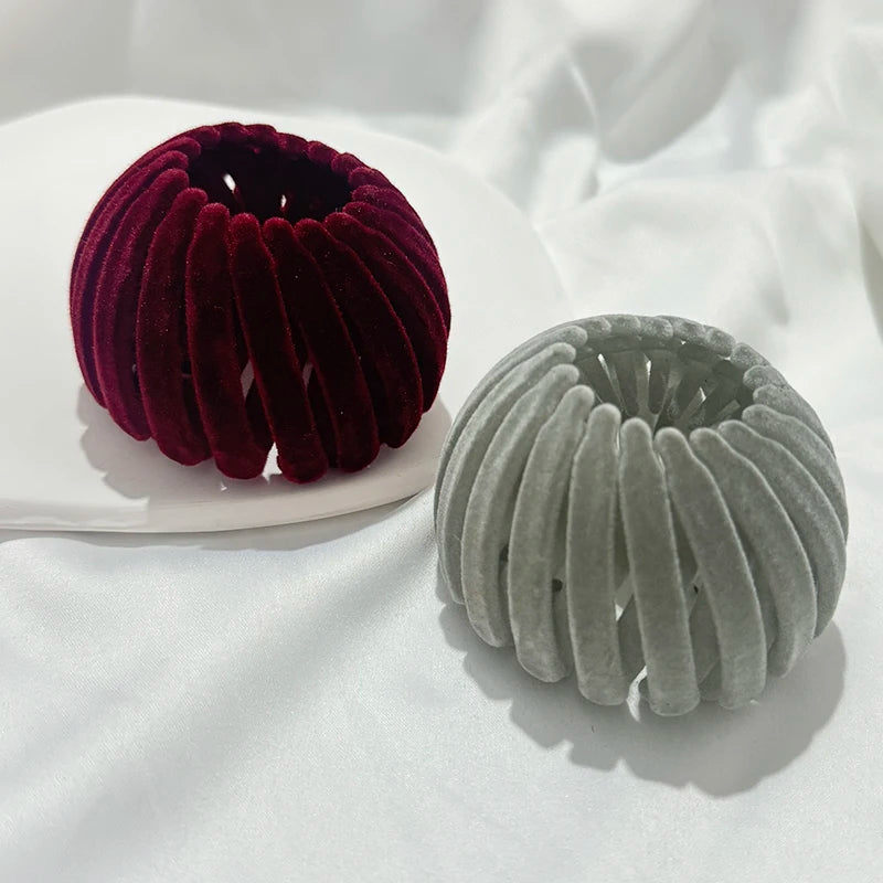 A pair of elegant horsetail hair clips, one in deep burgundy and one in light gray, resting on a white surface.