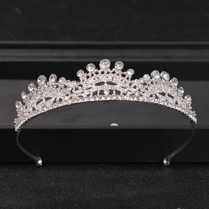 A sparkling crystal rhinestone bridal tiara headpiece displayed on a dark surface.