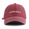 A maroon baseball cap with white embroidered text that reads overstimulated