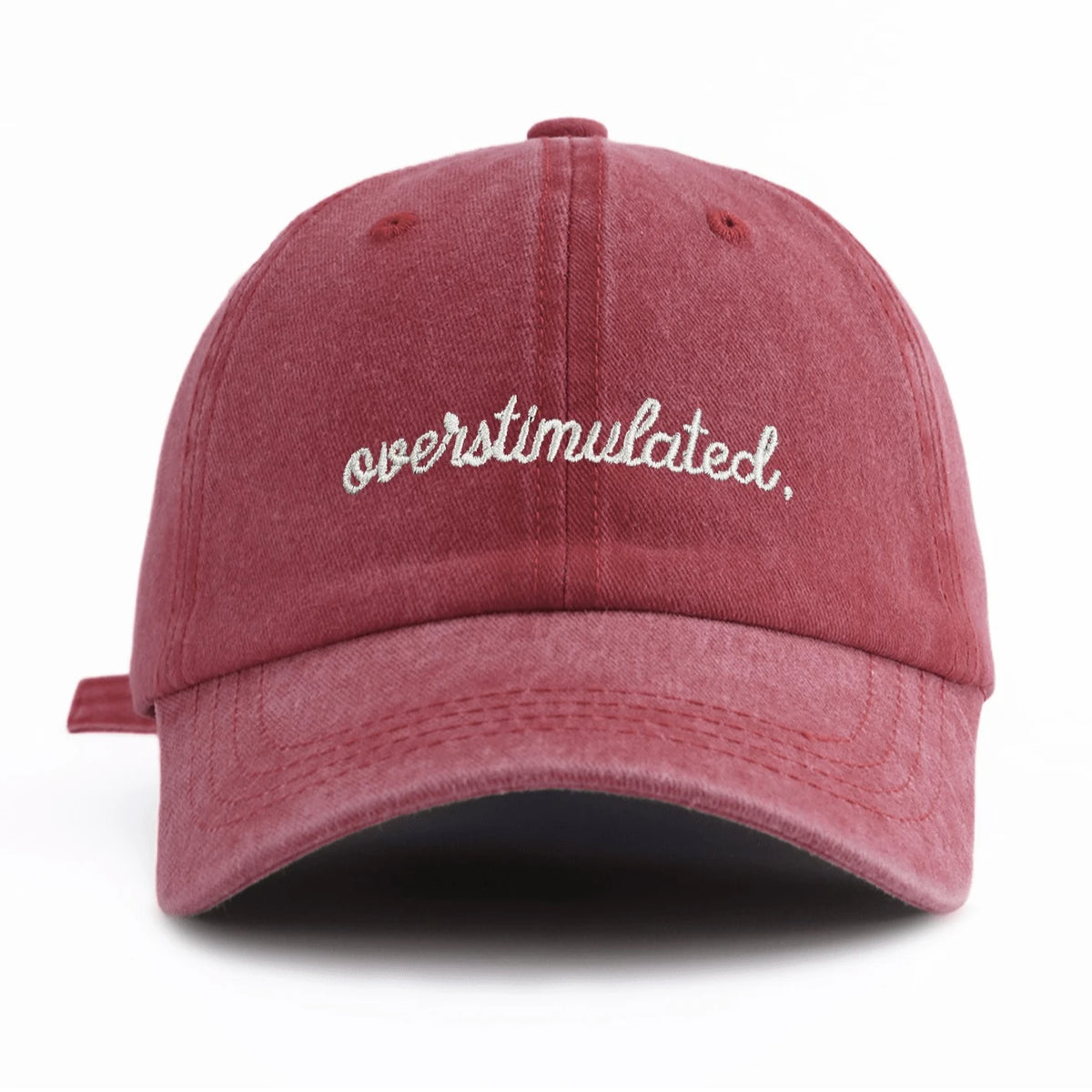 A maroon baseball cap with white embroidered text that reads overstimulated