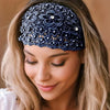 A close-up of a woman wearing a dark blue crystal pearl floral beaded headband on her hair.
