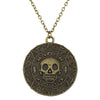 A gold-toned skull pendant necklace featuring an intricate design and decorative elements.