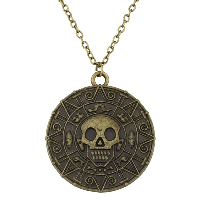 A gold-toned skull pendant necklace featuring an intricate design and decorative elements.