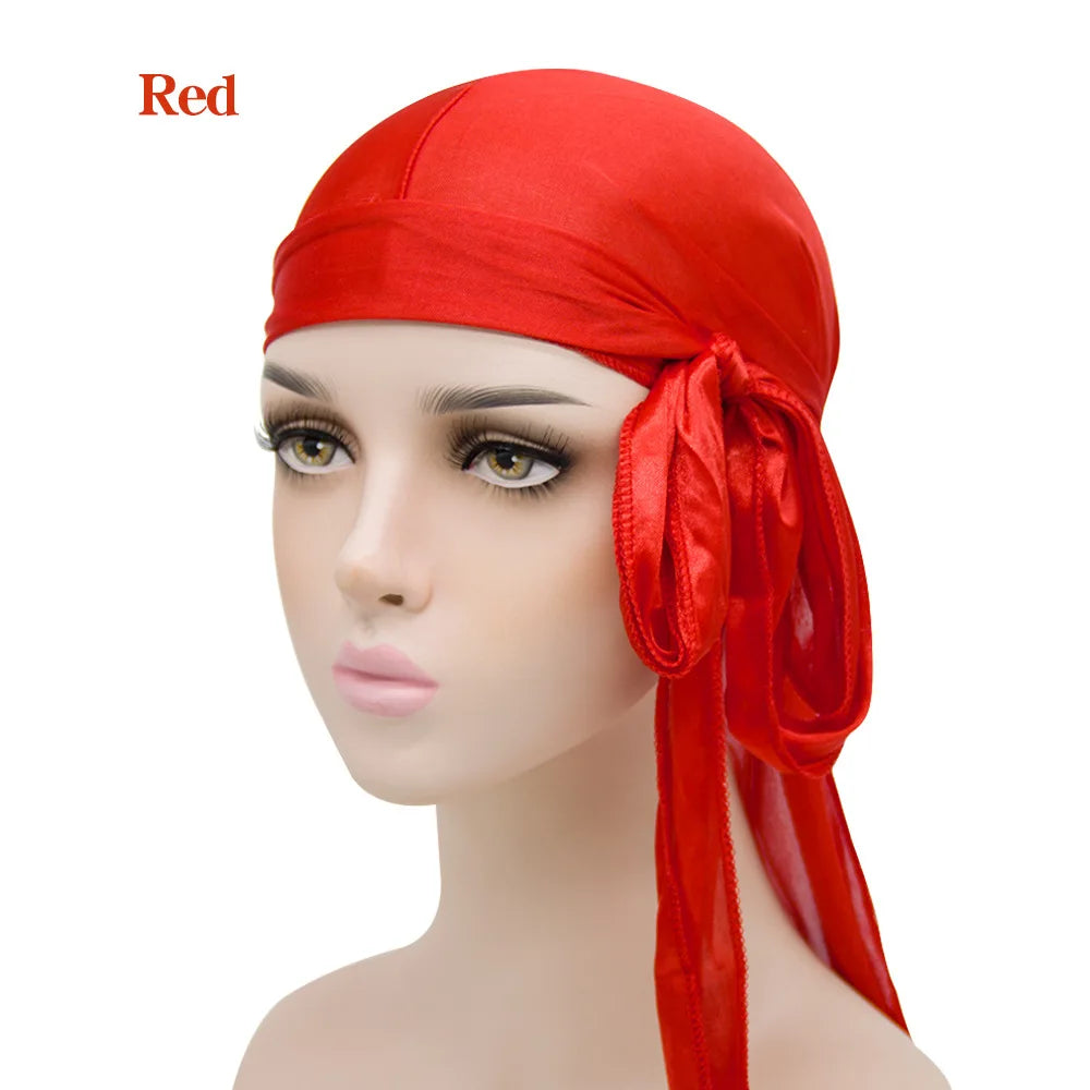 Pañuelo turbante de seda roja en forma de turbante, exhibido en un maniquí.