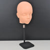 A light peach-colored professional mannequin head mounted on a black stand.