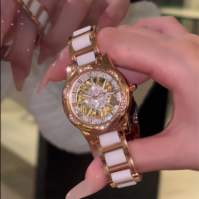 Primer plano de un reloj de pulsera de diamante de cuarzo dorado y blanco sostenido por una mano.