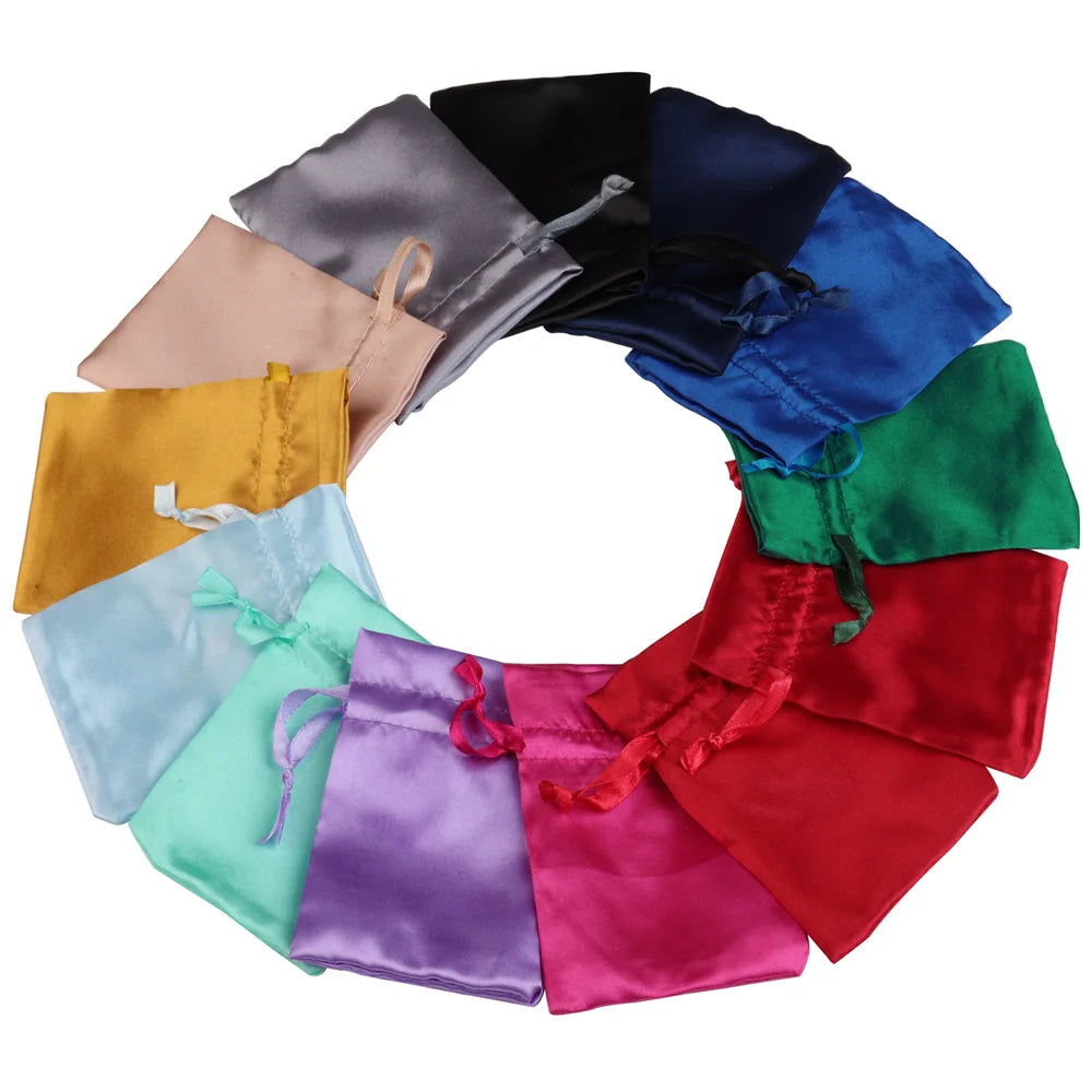 A circular arrangement of satin drawstring jewelry pouches in various colors including black, blue, green, red, purple, and g