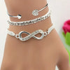 A set of three silver crystal heart charm bracelets displayed on a person's wrist.