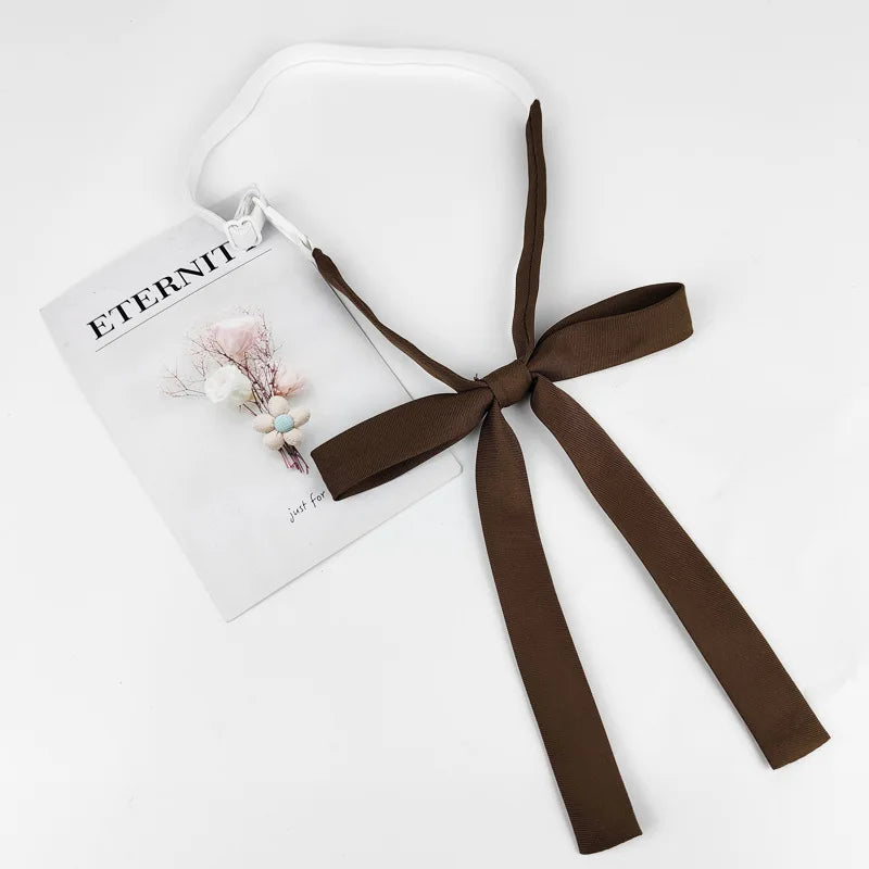 A brown ribbon tie set with a butterfly decoration is displayed next to a card titled Eternit.