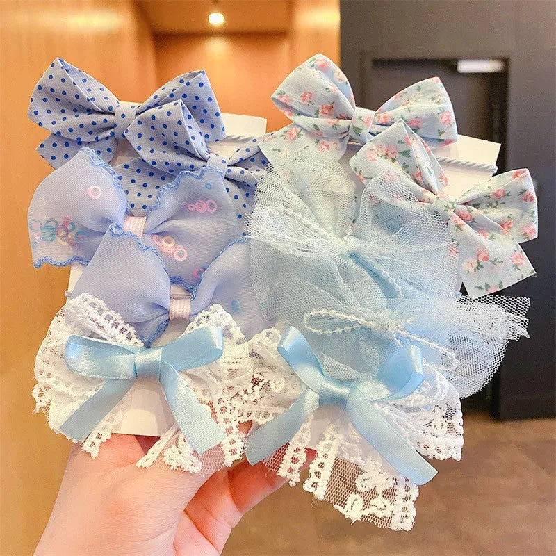 A collection of light blue and pink floral fabric bows and lace hair ties for girls