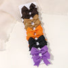 A collection of nine handmade ribbon bow hair clips in various shades including black, tan, gold, orange, and purple.