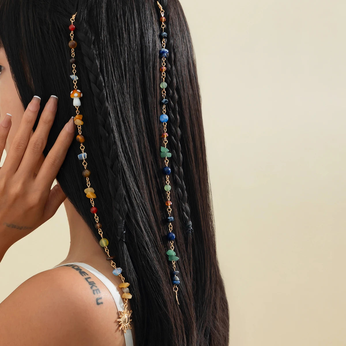 A close-up of a woman's dark hair adorned with a long, colorful bohemian sun moon tassel headdress.