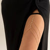 Gold boho crystal leg thigh body chain jewelry worn on a person's arm.