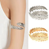 Set of six gold-plated swirl cuff armbands shown on a wrist.