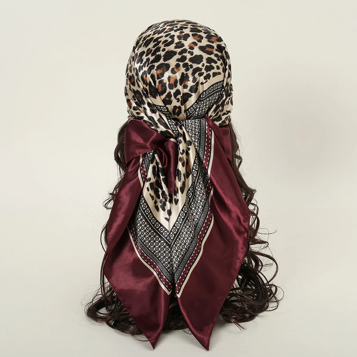 Dunkelburgunderer Satin-Seiderschal mit Leopardenmuster als Stirnband gebunden.