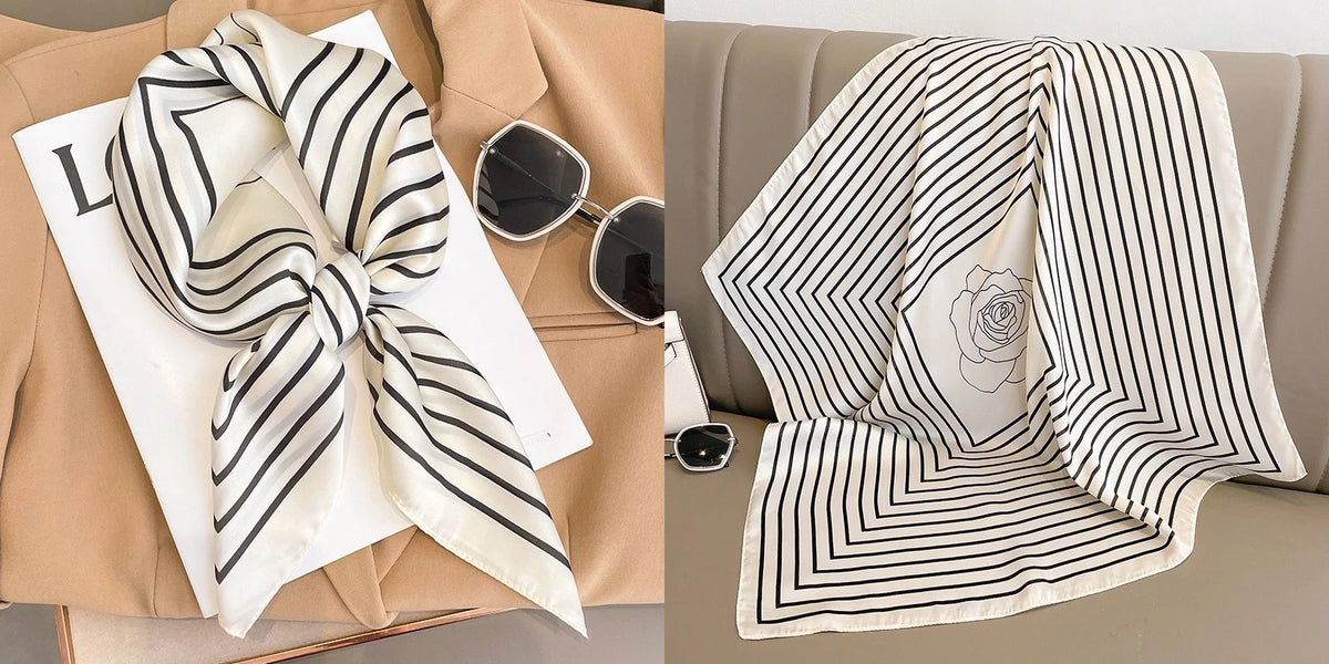 A striped silk scarf in black and white with a rose design is displayed on a beige blazer and draped over a sofa.