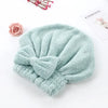 A soft mint green microfiber hair drying towel tied in a bow, placed next to a pink rose and a card labeled Eternity.