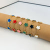 A line of gold plated stainless steel double-sided petal bracelets in various colors like blue, red, pink, and green, display