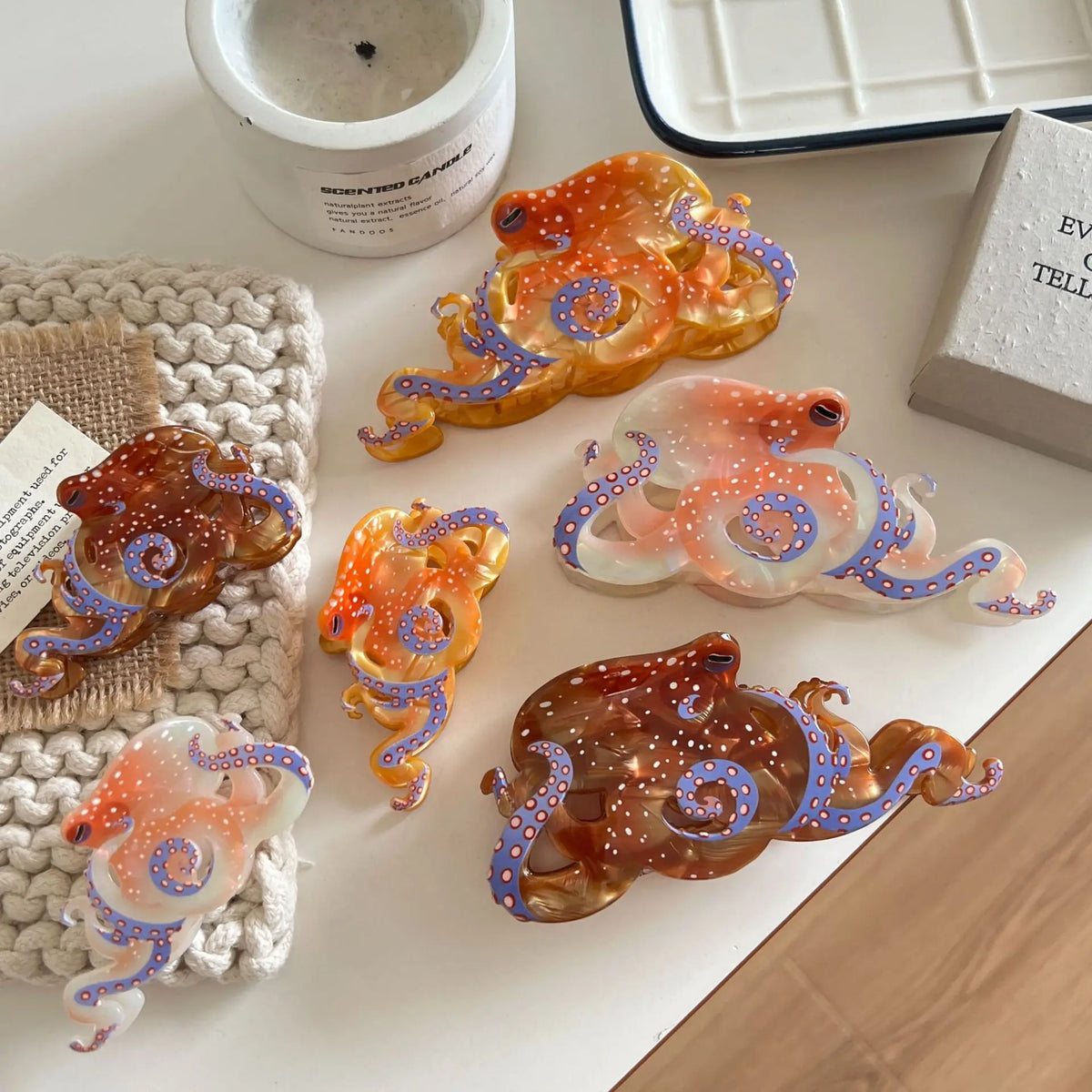 Collection de pinces à cheveux en forme d'octopus colorées avec des paillettes orange, violettes et bleues sur un fond blanc