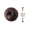 A spool of dark brown synthetic hair used for making buns, shown next to a measurement scale.