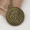 A round, antique brass pendant featuring a stylized pentacle design, suspended from a gold-colored chain.