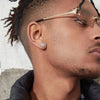 A close-up of a man wearing gold-plated simulated diamond stud earrings in his ear.