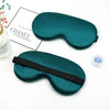 A dark teal silk sleep mask with a black strap is shown next to a box labeled Chanel.