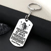 A silver stainless steel tag with a silhouette of a couple and text in Spanish hangs from a keyring.