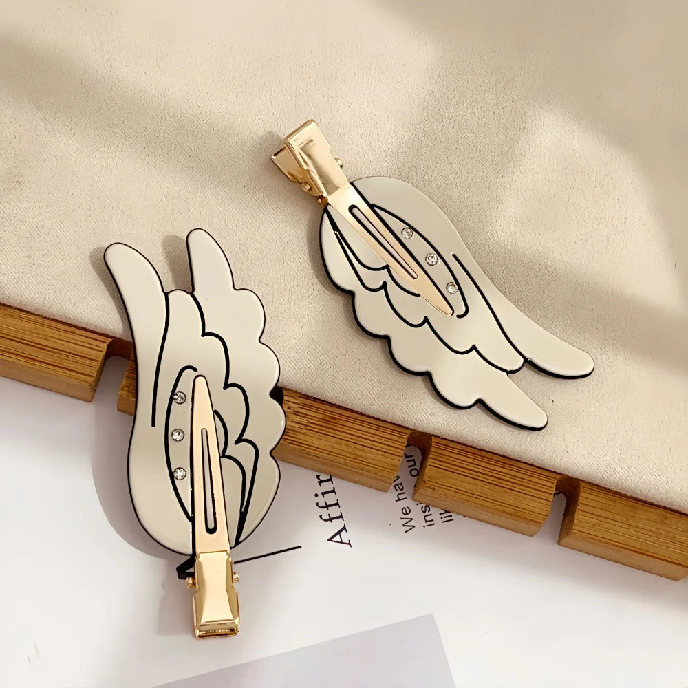 Gold-toned angel wing hair clips and barrettes displayed on a light background.