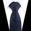 A dark blue paisley silk necktie with floral patterns shown against a white shirt.