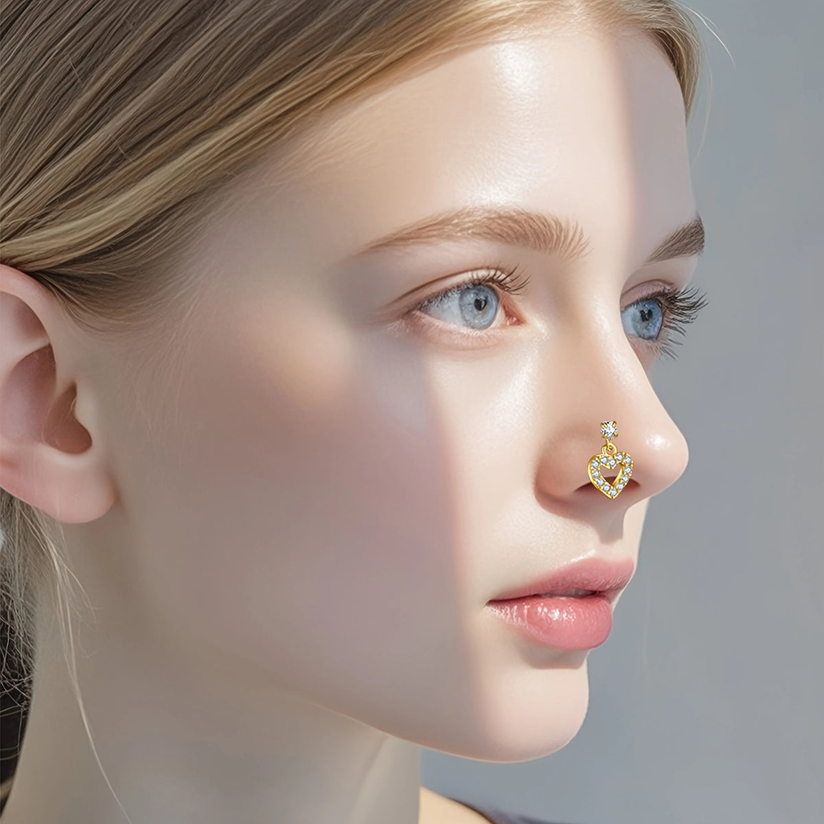 Gros plan du nez d'une femme montrant un piercing à l'oreille en forme de L en acier inoxydable doré délicat.