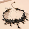 A black lace choker necklace featuring dark beads and gold accents.