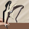 Three sleek hair sticks in black, cream, and brown are shown being held by a hand.