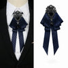 A dark blue velvet bow tie with silver rhinestone embellishments worn on a white shirt and black suit jacket.