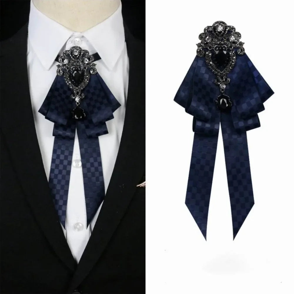 A dark blue velvet bow tie with silver rhinestone embellishments worn on a white shirt and black suit jacket.