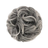 A close-up view of messy bun hair pieces scrunchies in a dusty gray color.